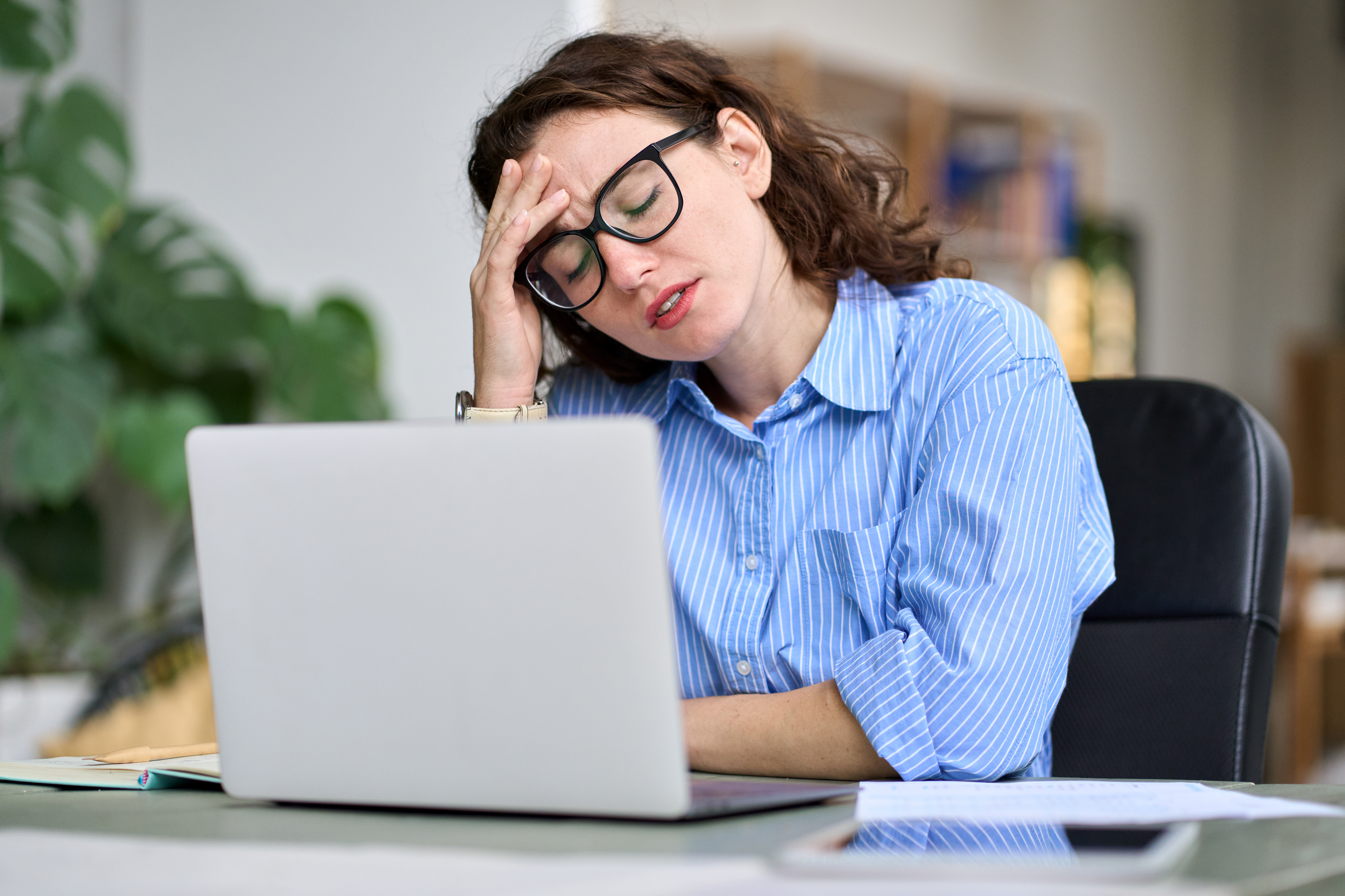 A professional stressed out in front of her laptop