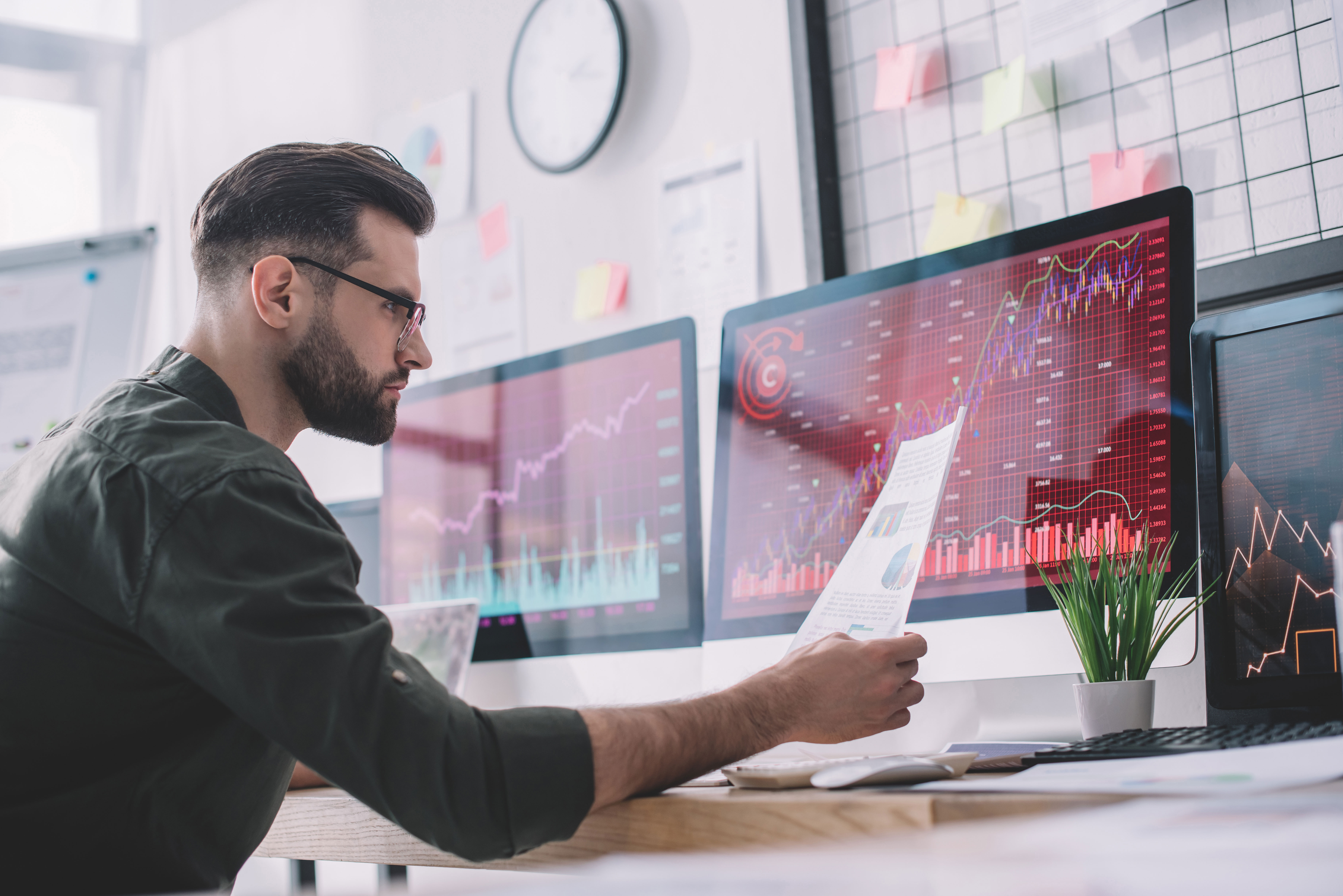 A data professional looking at charts on his monitors